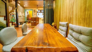 A wooden dining table with chairs, a sofa, and a teddy bear. - Cat Lazy B&B (Luodong)