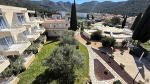 A residential area with modern buildings, a central courtyard, and surrounding hills. - Agi Rescator 212 Apartamento for rent in Roses Girona. (Rosas / Roses)