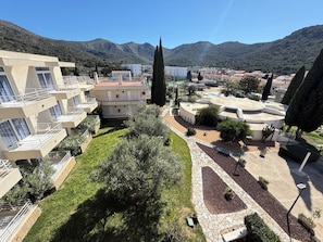 A residential area with modern buildings, a central courtyard, and surrounding hills.