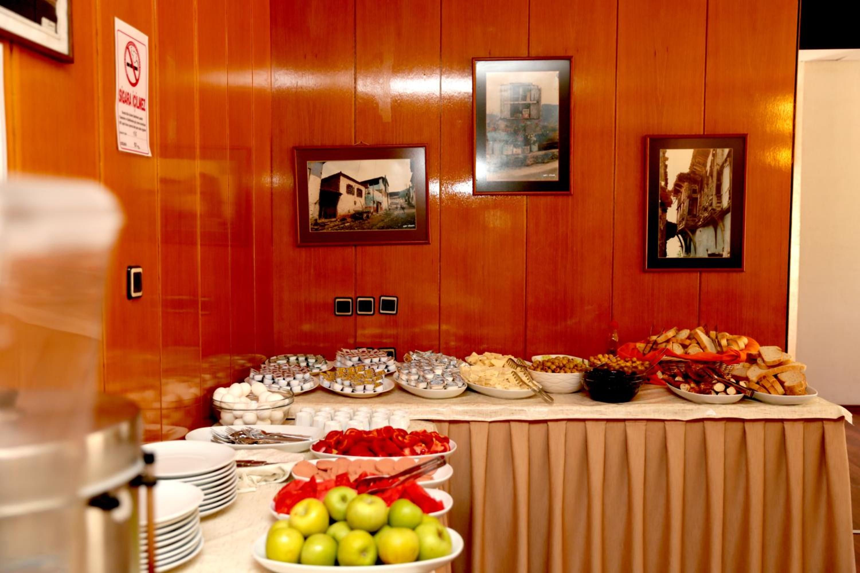 Une table de buffet garnie de divers plats et un panneau « interdiction de fumer » accroché au mur.