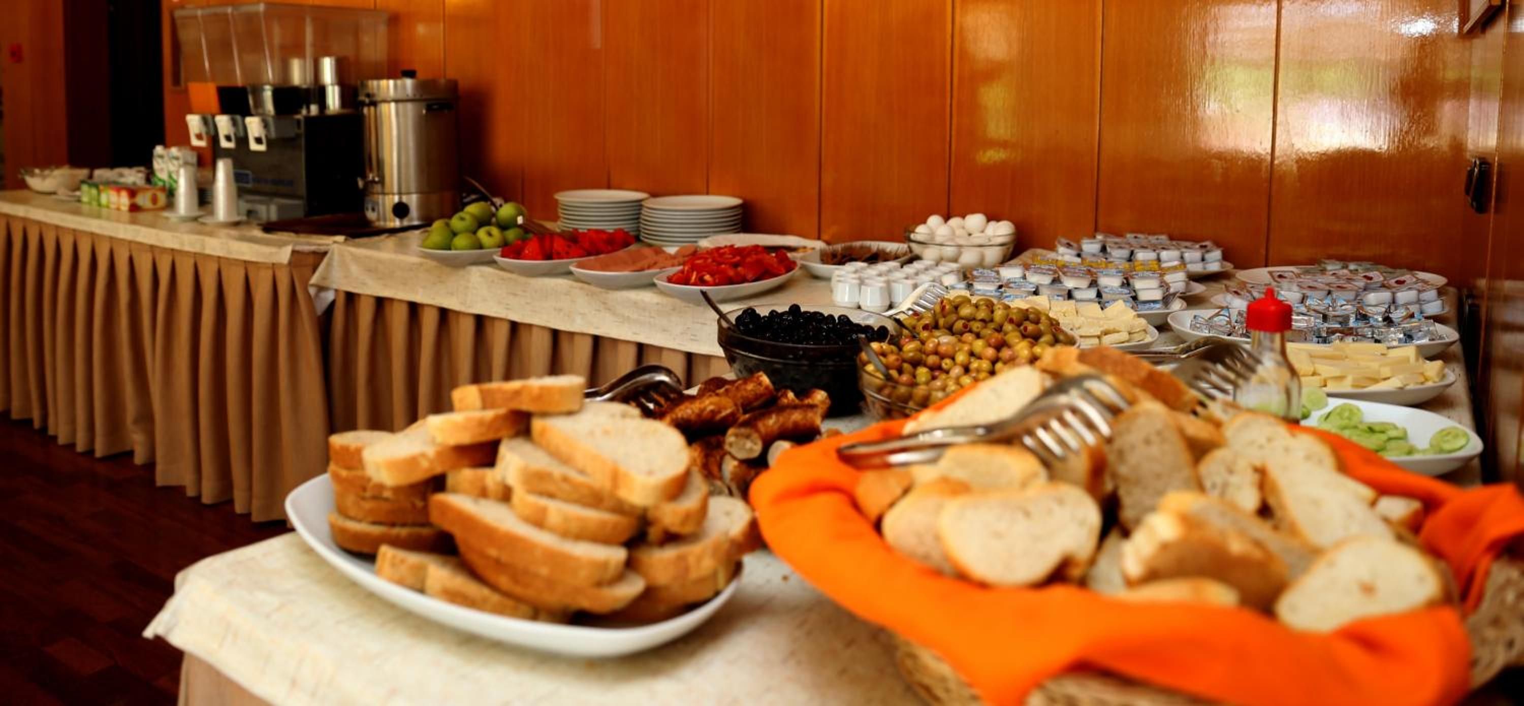 A buffet table with various food items and condiments.