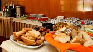 A buffet table with various food items and condiments.