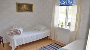 A bedroom with a single bed, a window with curtains, a radiator, and a painting on the wall. - 3 bedroom lovely home in Lammhult (Lammhult)