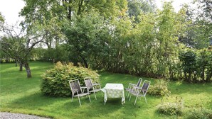 A grassy outdoor area with a table and four chairs. - 3 bedroom lovely home in Lammhult (Lammhult)