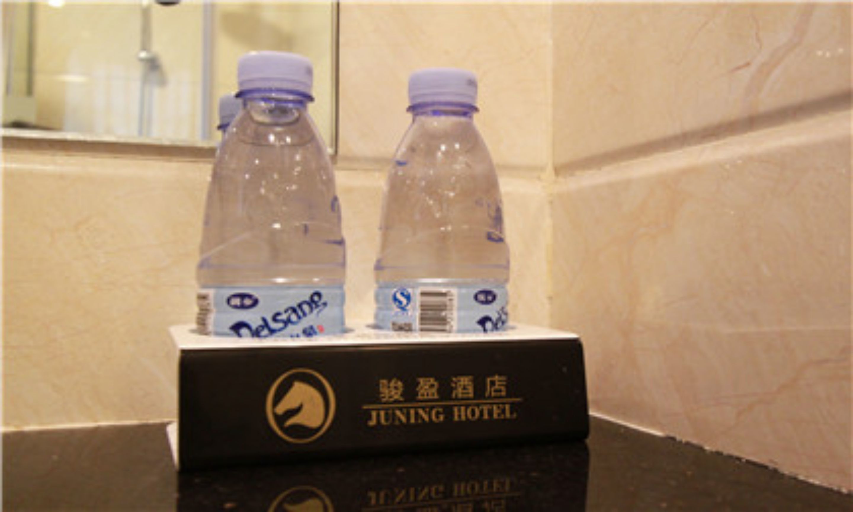 Two water bottles on a black box with hotel branding.