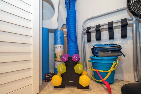 A small storage area with exercise equipment, including dumbbells and a yoga mat. - Princeville 2br w/ AC, curated local art, walk to Anini Beach,shopping,dining (Princeville)