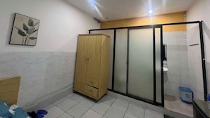 A small, compact bathroom with a wooden cabinet, a sliding glass door shower, and a tiled floor. - 95 Lam Son Hotel (Ho Chi Minh City)