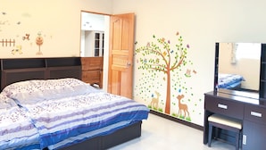 A bedroom with a bed, a dresser, a mirror, and a wall with a tree mural. - Look Tea House (Meishan)