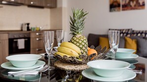 Una mesa de comedor servida con platos, tazones y un centro de frutas.