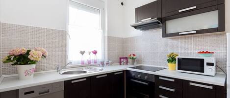 A modern kitchen with dark cabinets, a microwave, and a dishwasher.
