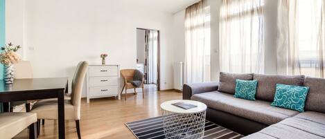 Ein modernes Wohnzimmer mit einer Couch, einem Esstisch und einem Couchtisch.