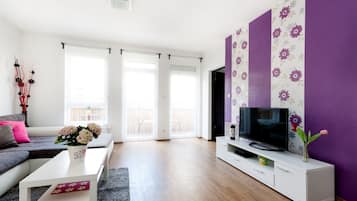 Apartamento superior, 3 quartos, sacada, vista para a cidade | Área de estar | TV de tela plana