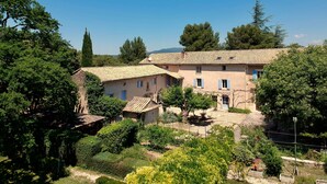 Un bâtiment traditionnel doté de nombreuses pièces, d’une cour et entouré de verdure.