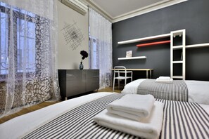 Relax in a spacious room with a large bed, desk, and shelving unit, perfect for work and rest.