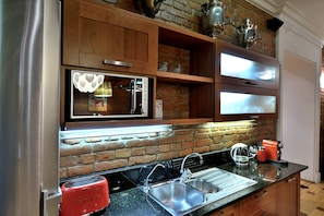 Enjoy cooking in this well-equipped kitchen with a stainless steel refrigerator, double sink, and modern faucet.