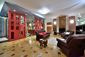Relax in this inviting living room with a fireplace, leather sofa, and large mirror.