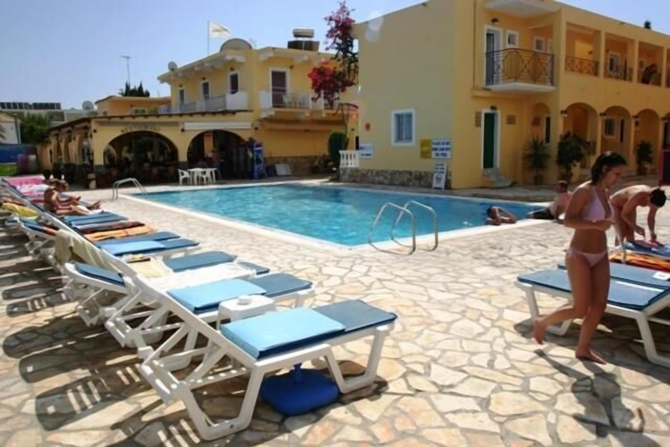 Un área junto a la piscina con sillones de descanso y una pileta.