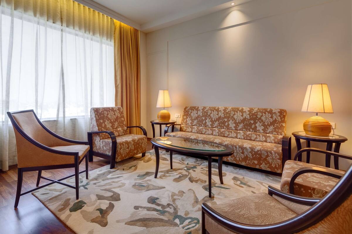 A living room with a sofa, two armchairs, a coffee table, and two lamps.