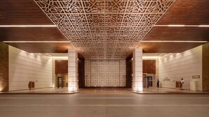 A spacious lobby with a geometric ceiling design, a central column, and a reception desk. - Balaji Sarovar Premiere Solapur (Solapur)