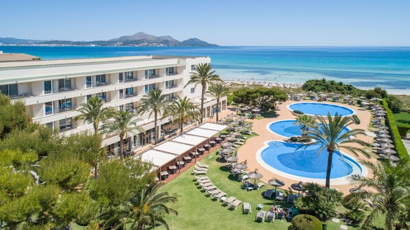 A resort with a large pool area, multiple lounge chairs, and a view of the ocean. - Grupotel Natura Playa (Muro)