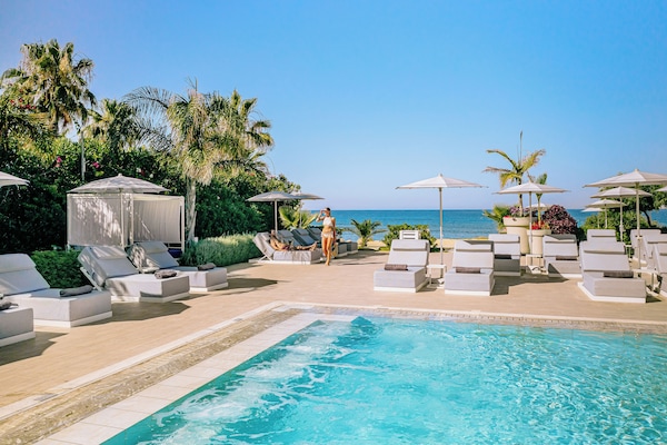 Alberca techada, alberca al aire libre y sombrillas en la alberca