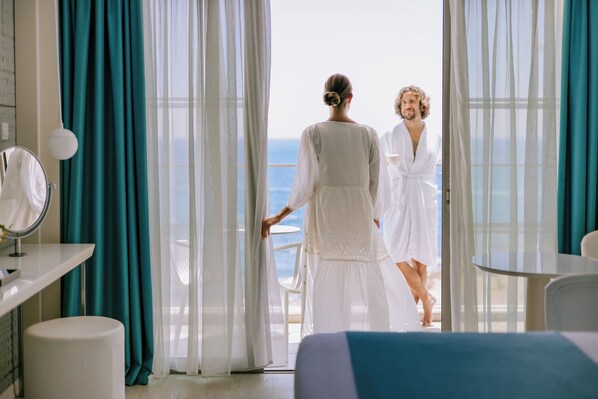 A hotel room with a balcony, a bed, a small table, and a mirror. - Ivi Mare - Designed for adults by Louis Hotels (Geroskipou)