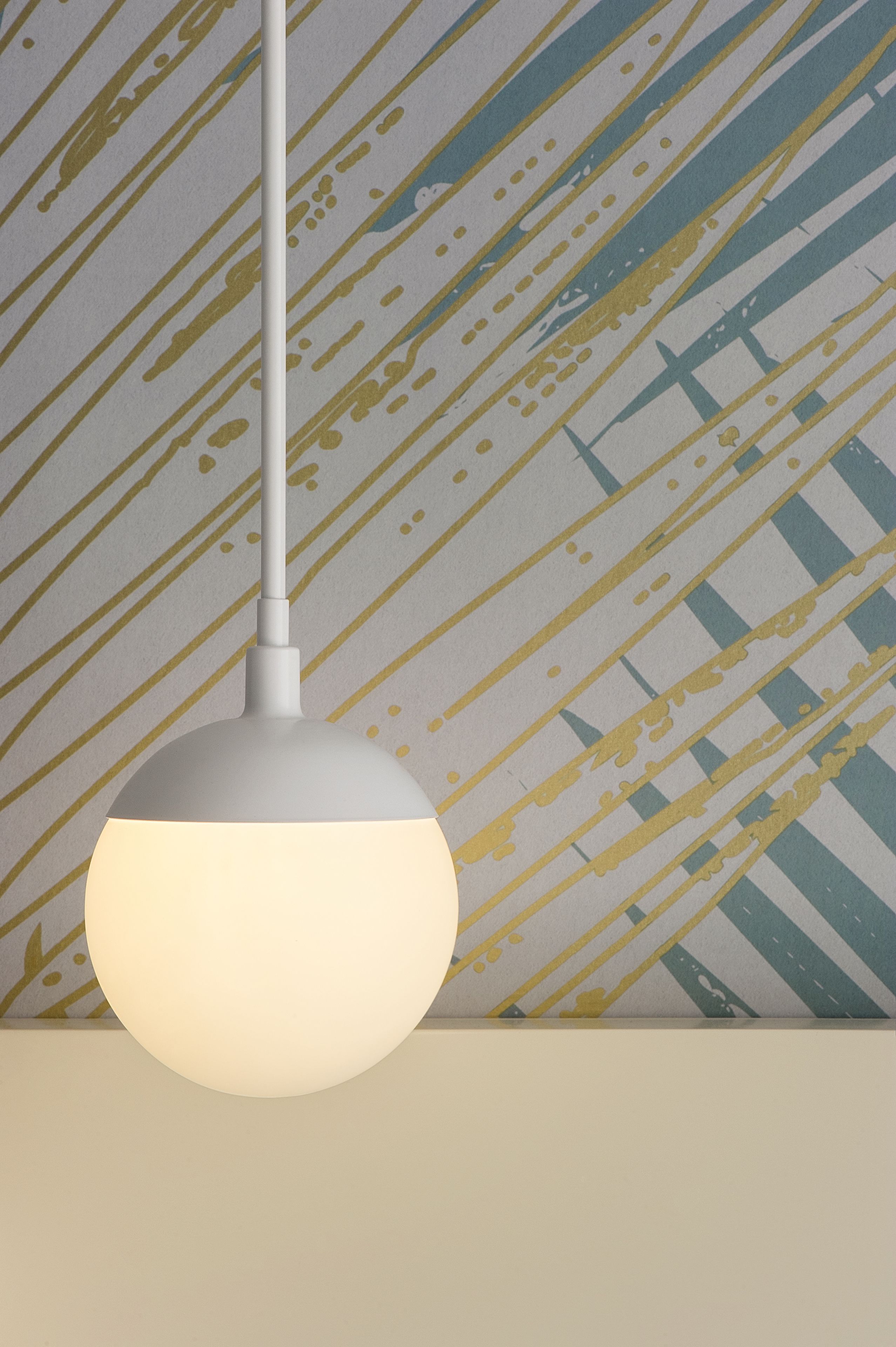 A pendant light fixture with a white shade hanging from a ceiling.