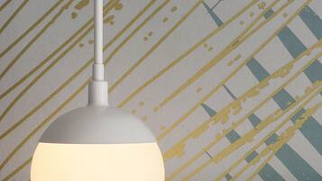 A pendant light fixture with a white shade hanging from a ceiling.
