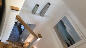 A wooden staircase with a view of a painting on the wall. - Chyreen@marazion (Marazion)