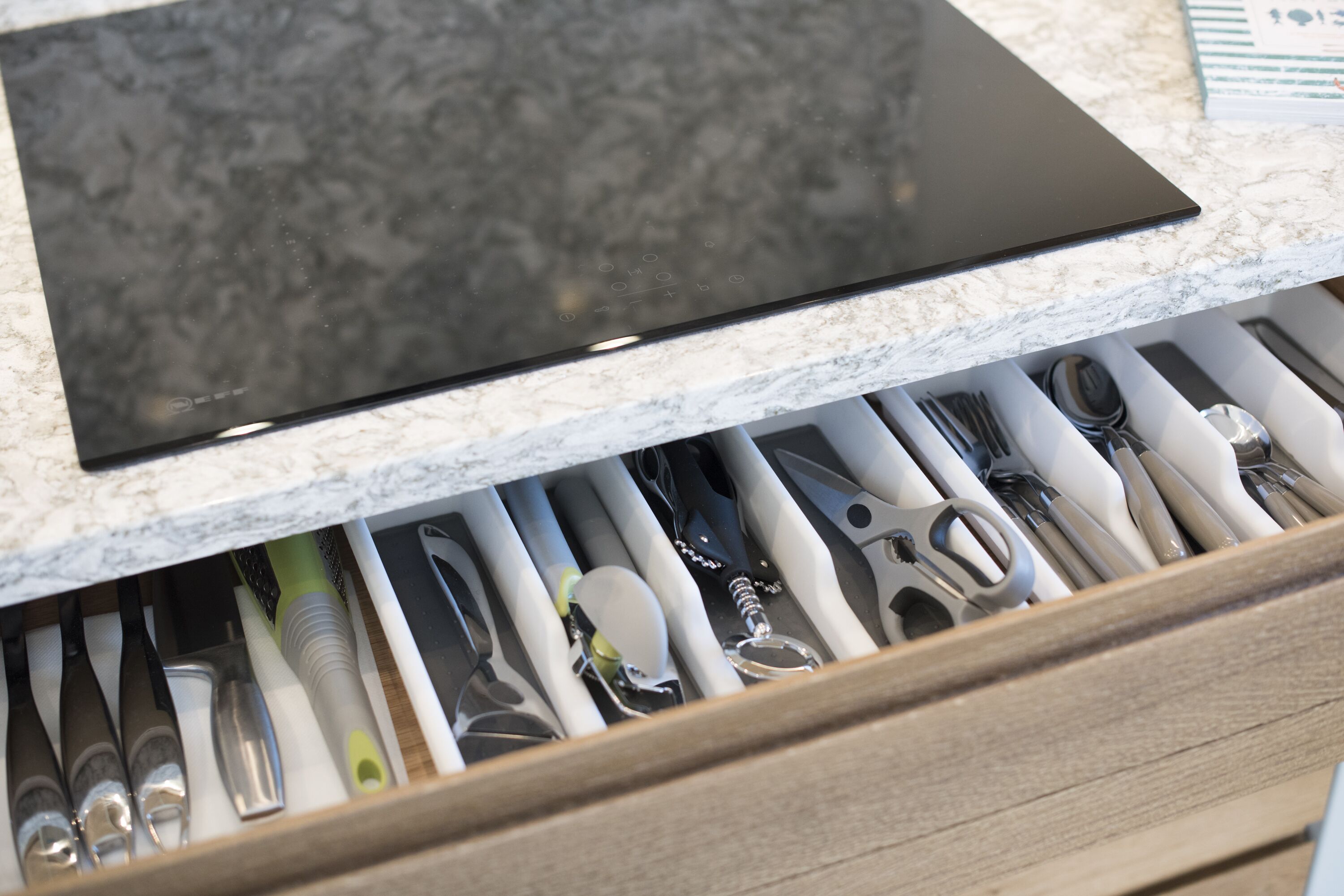 A drawer with various kitchen utensils.