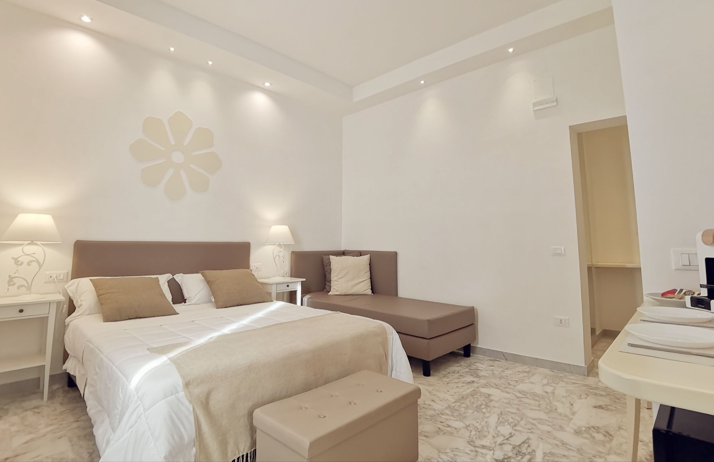 Une chambre à coucher avec un grand lit, un canapé, une table de chevet et un bureau avec une chaise.