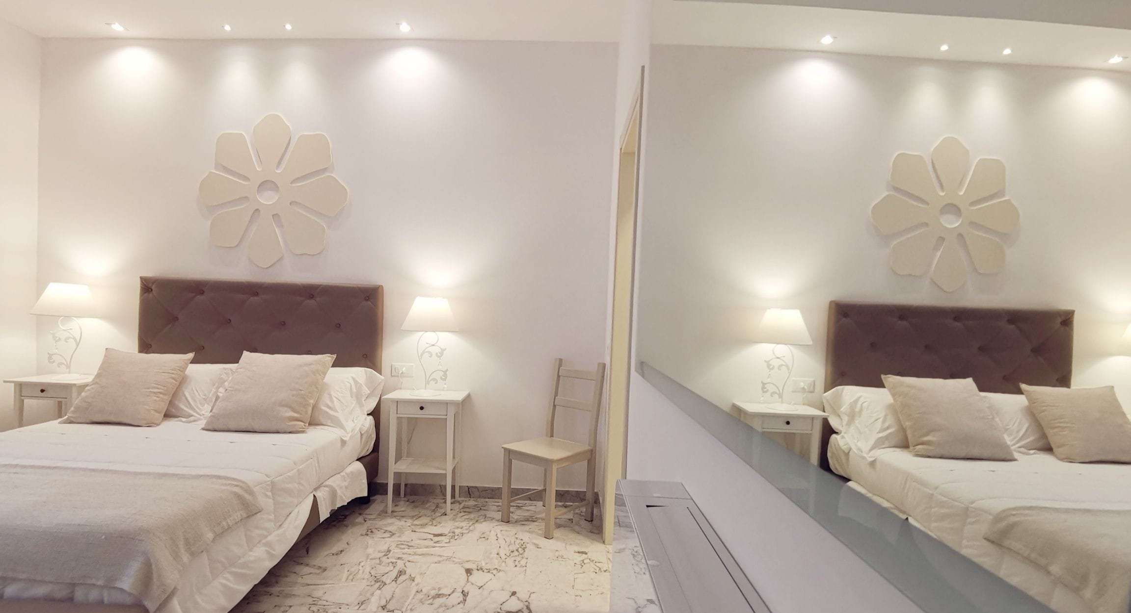 Une chambre à coucher comprenant un lit, deux tables de chevet, une chaise et une décoration florale fixée au mur.