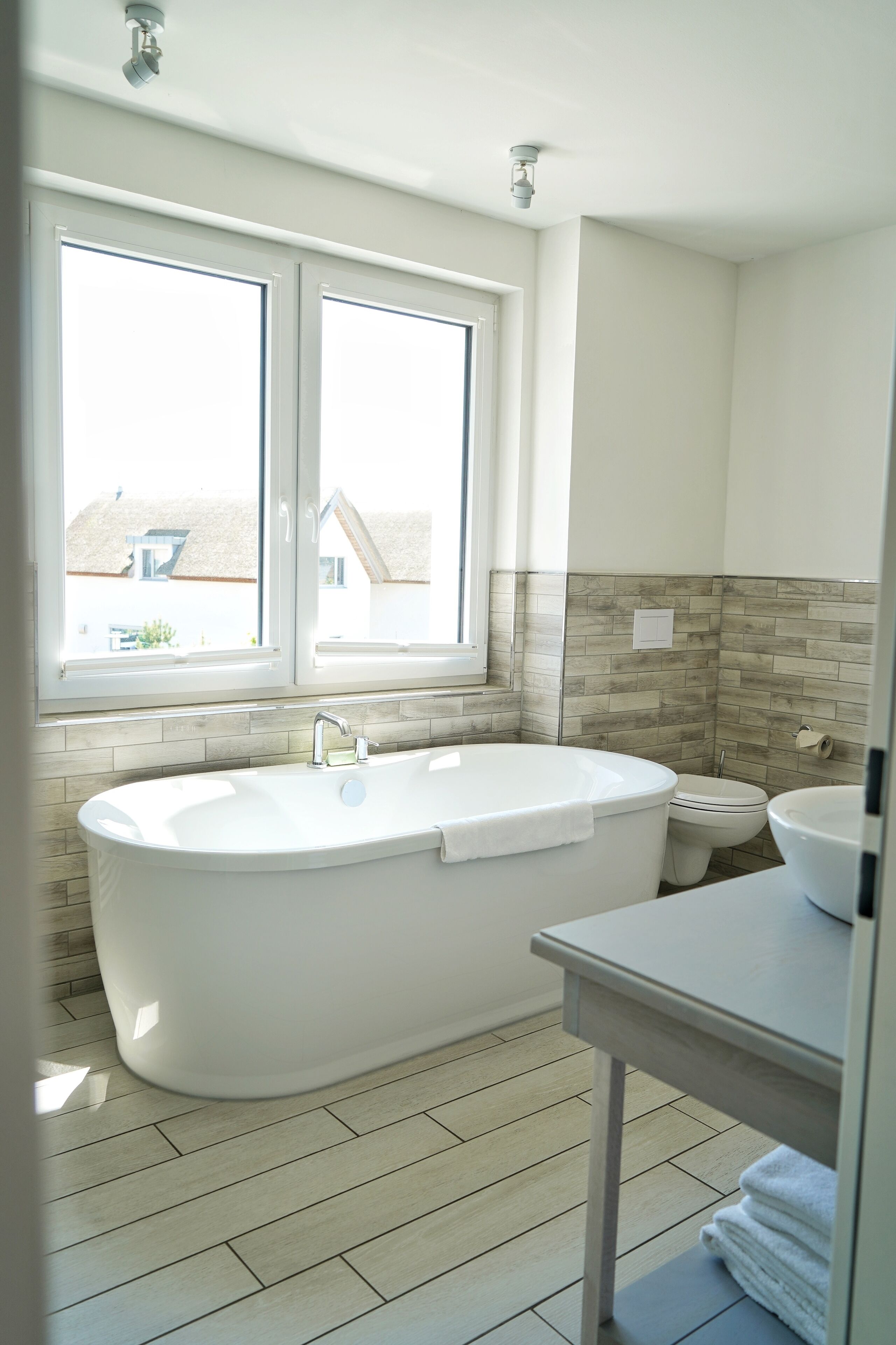 A modern bathroom with a freestanding bathtub, a toilet, and a sink.