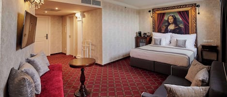 A hotel room with a large bed, a red carpet, a sofa, and a painting of the Mona Lisa on the wall.