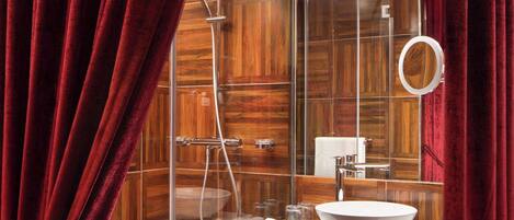 A modern bathroom with a glass-enclosed shower, a wooden vanity, and a large mirror.