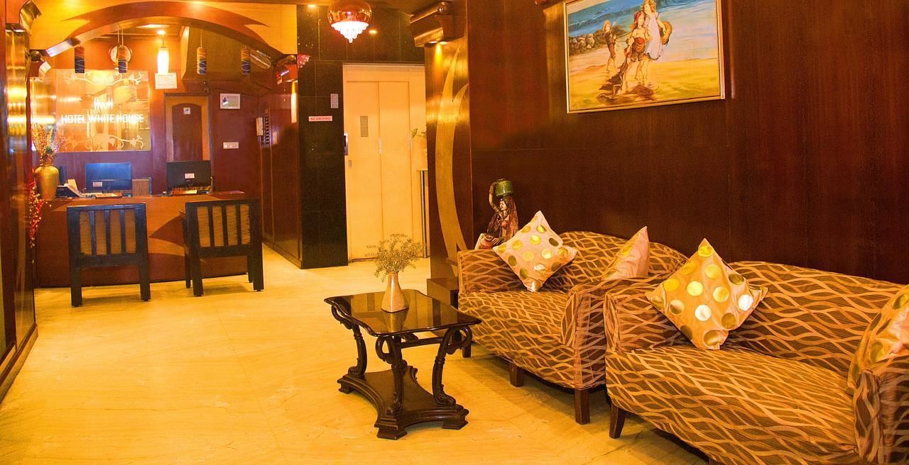 A lobby with a reception desk, seating area, and a painting on the wall.