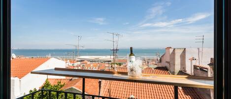 Un balcón con vista al mar y edificios.