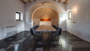 A conference room with a long table, black chairs, and a vaulted ceiling.