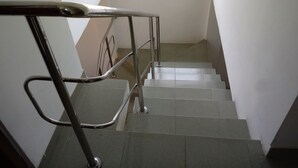 A staircase with metal handrails and a window above.