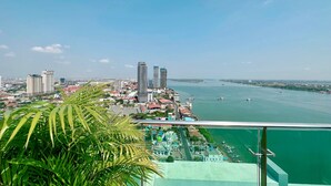 Un immeuble de grande hauteur offrant une vue sur le paysage urbain et un plan d’eau.