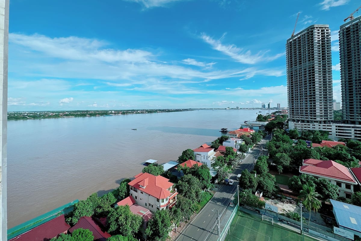A river with buildings on one side and a bridge in the distance.