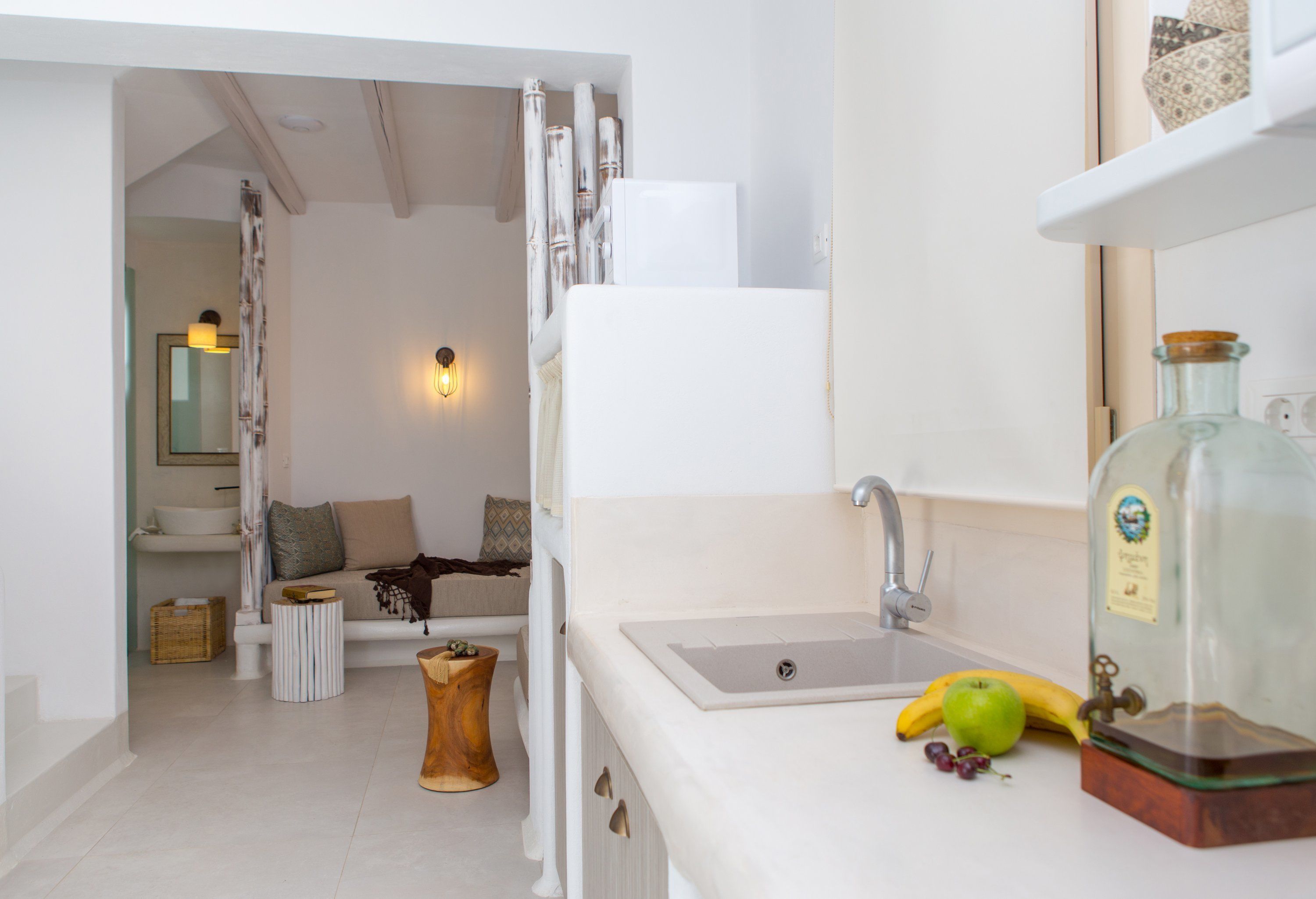 A bathroom with a white sink, a mirror, and a bottle of liquid soap.