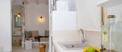 A bathroom with a white sink, a mirror, and a bottle of liquid soap.