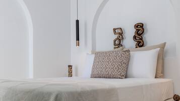A modern bedroom with a large bed, a hanging light fixture, and decorative wall art.