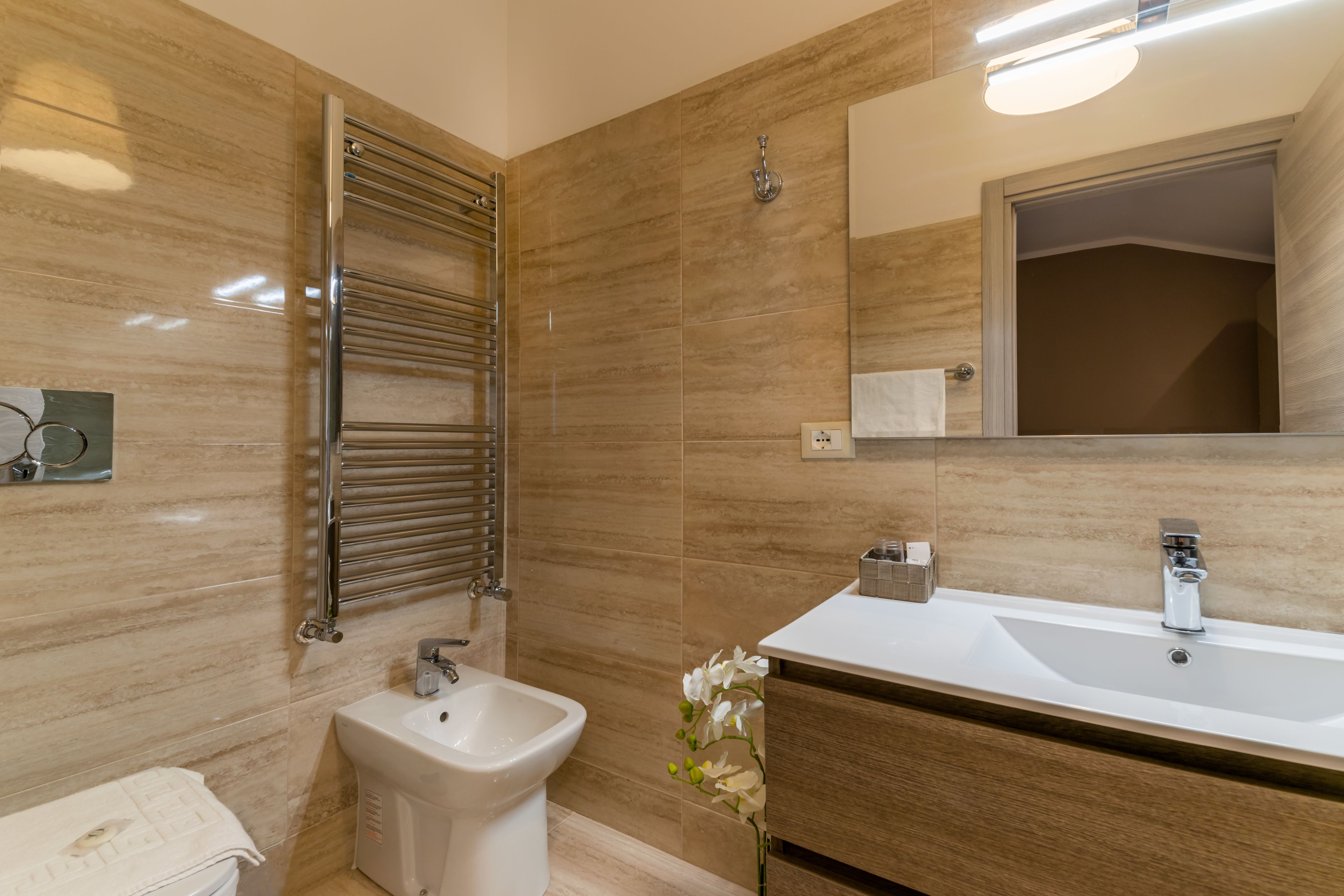 Een moderne badkamer met een bidet, een wastafel en een spiegel.