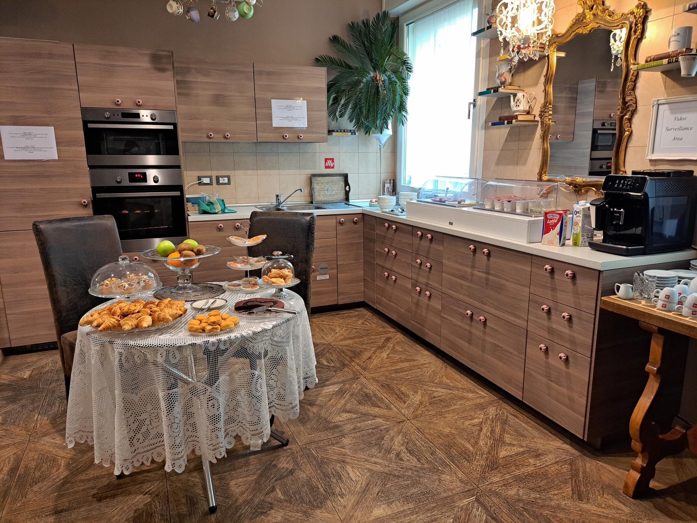 Una cocina moderna con armarios de madera, electrodomésticos de acero inoxidable y un comedor con mantel de encaje.