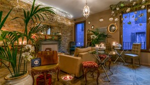 Un salon chaleureux avec une cheminée, des sièges confortables et des plantes décoratives.