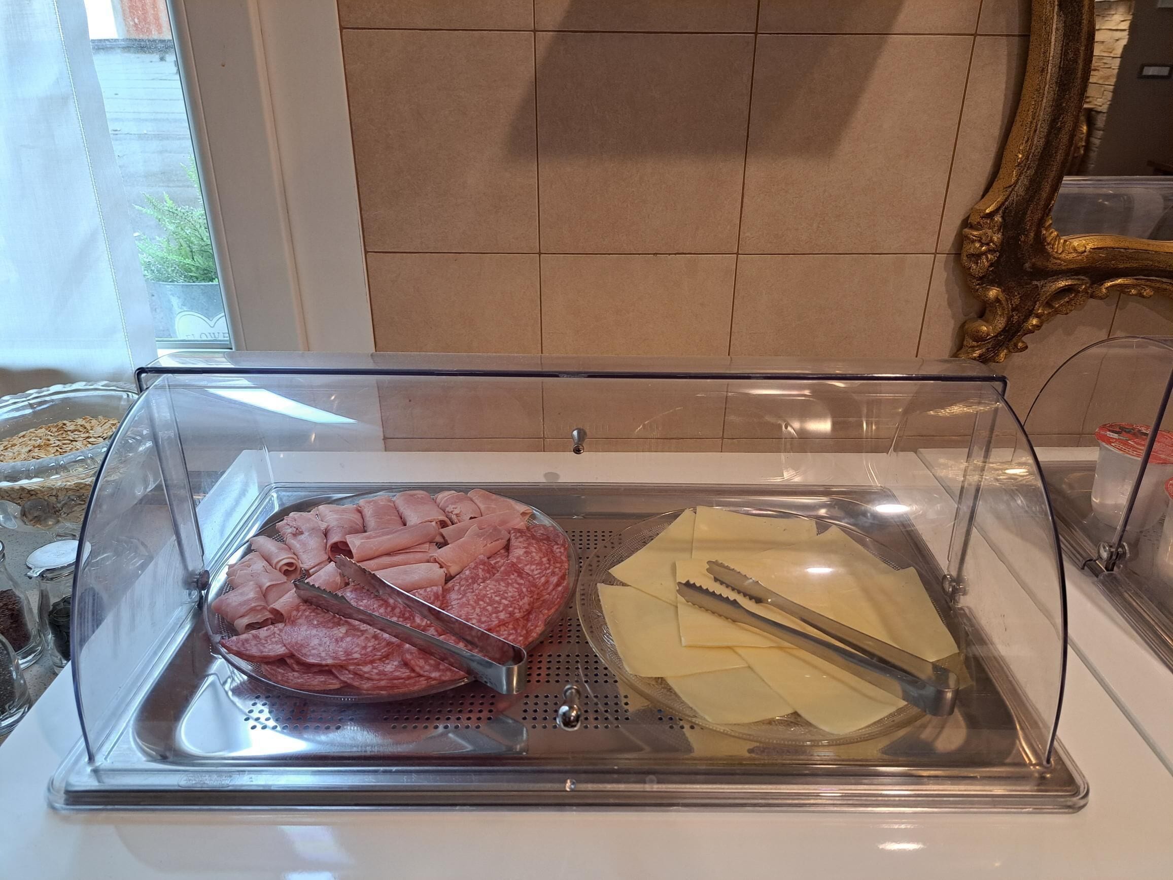 A deli display case with sliced meats and cheeses.