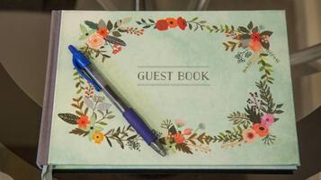 Un libro de visitas con un diseño floral y un bolígrafo azul encima.