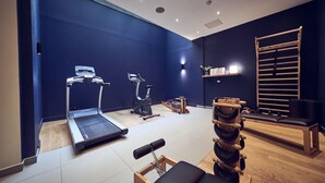A gym with a treadmill, stationary bike, and various exercise equipment. - Maison Nô (Lyon)
